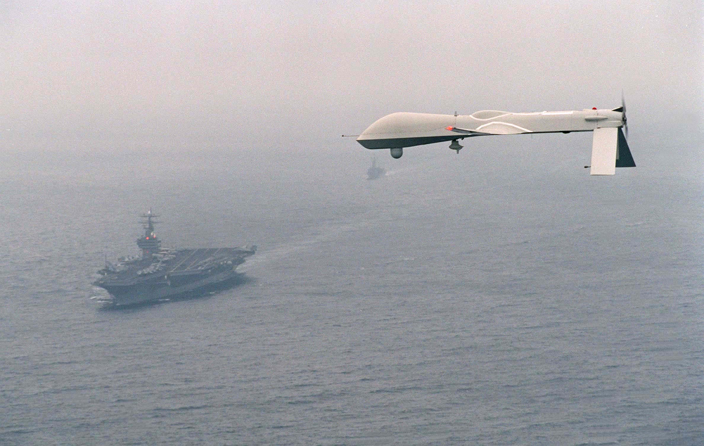 THE PREDATOR UNMANNED AERIAL VEHICLE (UAV) FLIES ABOVE USS CARL VINSON (CVN 70) ON A SIMULATED NAVY RECONNAISSANCE FLIGHT HEADED BY COMMAND CARRIER GROUP ONE ON DECEMBER 5, 1995, ABOUT 100 MILES OFF THE SAN DIEGO COASTLINE. THE FLIGHT IS THE PREDATOR'S FIRST MARITIME MISSION WITH A CARRIER BATTLE GROUP; PROVIDING "NEAR REAL-TIME" INFRARED AND COLOR VIDEO TO THE SHIP DURING ITS FLIGHT. THE PREDATOR, LAUNCHED FROM SAN NICHOLAS ISLAND 0FF THE SOUTHERN CALIFORNIA COASTLINE, IS CAPABLE OF OVER 50 HOURS OF NON-STOP FLIGHT AND IS OPERATED BY A JOINT ARMED SERVICES DETACHMENT. THE DETACHMENT CONSISTS OF A CREW OF MILITARY PILOTS, TECHNICIANS, OPERATORS AND ANALYSTS. THE NAVY'S PLANS FOR THE PREDATOR IN FUTURE EXERCISES AND OPERATIONS INCLUDE SHIP RECONNAISSANCE, BATTLE-DAMAGE ASSESSMENT, AND SEARCH AND RESCUE MISSIONS. PREDATOR HAS A WINGSPAN OF 48.4 FEET, A LENGTH OF 26.7 FEET AND WEIGHS APPROXIMATELY 1500 POUNDS WHEN FULLY FUELED. COST OF THE AIRCRAFT IS AROUND 3.2 MILLION DOLLARS. AVERAGE SPEED IS APPROXIMATELY 70 KNOTS.
